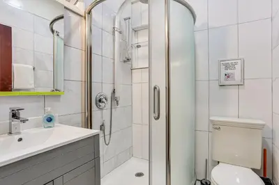 a bathroom with a shower and a toilet and a sink at 5 Mi to Monticello Raceway Cabin Near Shops in Mongaup Valley