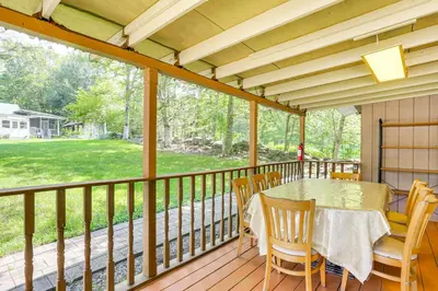 a screened in porch with a table and chairs at 5 Mi to Monticello Raceway Cabin Near Shops in Mongaup Valley