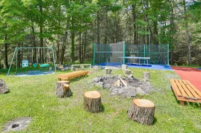 a park with a playground with benches and logs at 5 Mi to Marina and Raceways Mongaup Valley Retreat! in Mongaup Valley
