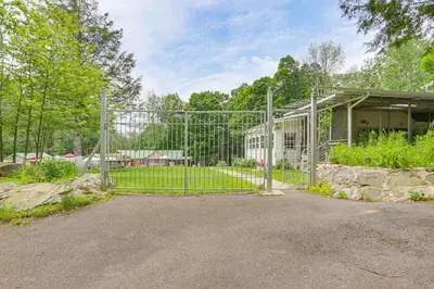 a gate in front of a yard with a house at 5 Mi to Marina and Raceways Mongaup Valley Retreat! in Mongaup Valley
