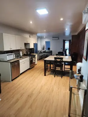 a kitchen and a living room with a table in a kitchen at Garden Apartment in New York