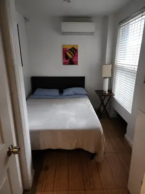a bedroom with a bed in a room with two windows at Garden Apartment in New York