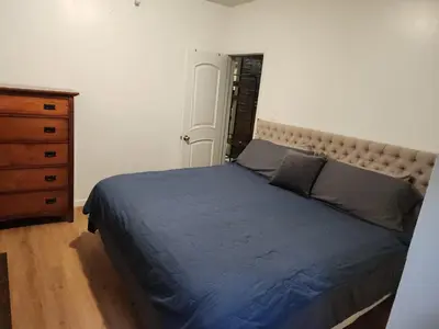 a bedroom with a large bed and a dresser at Garden Apartment in New York
