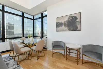 a dining room with a glass table and chairs at Opulent 2BR Duplex - Iconic Midtown Views in New York