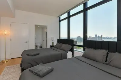a bedroom with two beds and a large window at Opulent 2BR Duplex - Iconic Midtown Views in New York