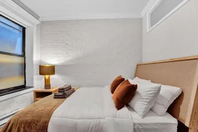 a bedroom with a large white bed with a window at Modern 3BR in Gramercy -Near Union Sq NYU in New York
