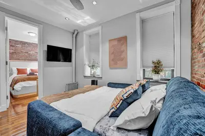a living room with a couch and a bedroom at Modern 3BR in Gramercy -Near Union Sq NYU in New York