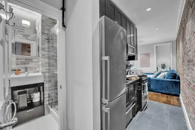 a kitchen with a stainless steel refrigerator at Modern 3BR in Gramercy -Near Union Sq NYU in New York