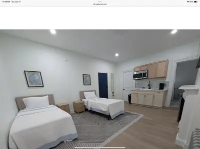 a bedroom with two beds and a kitchen at Sava apt rentals in Newark