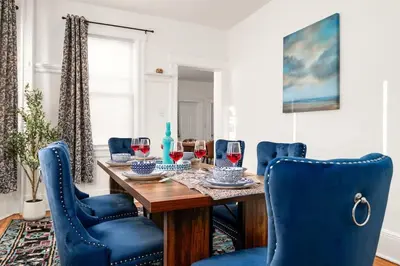 a dining room with a wooden table and blue chairs at Whole House Near NYC and Transit with Game Room Fire Pit and King Bed in New Rochelle