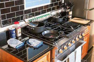 a kitchen stove with pots and pans on it at Whole House Near NYC and Transit with Game Room Fire Pit and King Bed in New Rochelle