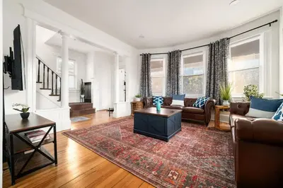 a living room with a couch and a table at Whole House Near NYC and Transit with Game Room Fire Pit and King Bed in New Rochelle