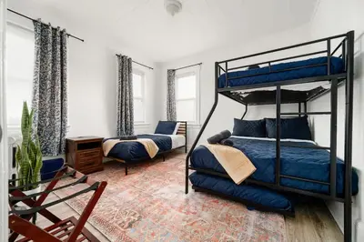 a bedroom with two bunk beds and a chair at Whole House Near NYC and Transit with Game Room Fire Pit and King Bed in New Rochelle