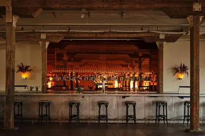 a bar with bar stools in a room at Pocketbook Hotel and Baths in Hudson