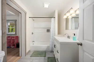 a white bathroom with a tub and a sink and a bath tub at Nature Getaway - Creek, Firepit, Deck, Privacy - Delaware River in Sparrow Bush