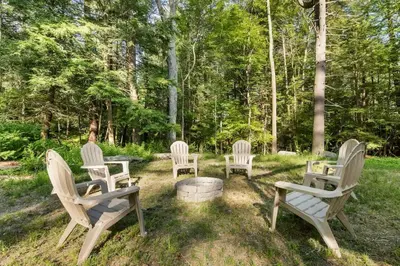 a group of chairs sitting in the grass at Nature Getaway - Creek, Firepit, Deck, Privacy - Delaware River in Sparrow Bush