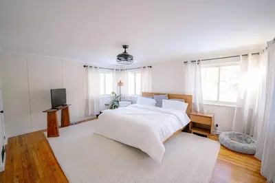 a bedroom with a white bed and a television at Oscawana Lake Escape in Putnam Valley