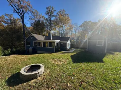 a yard with a house and a tire in the grass at Oscawana Lake Escape in Putnam Valley