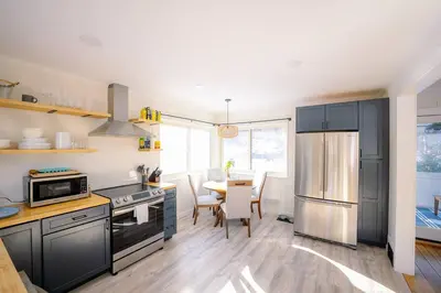 a kitchen with black cabinets and a table with a tableablish at Oscawana Lake Escape in Putnam Valley