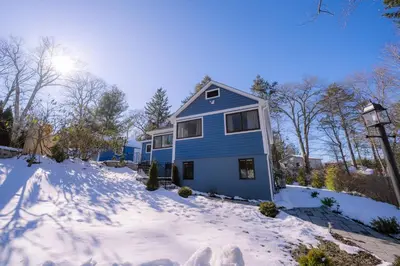 a blue house with snow on the ground at Oscawana Lake Escape in Putnam Valley