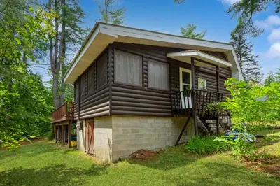 a small house in the middle of a yard at Adirondacks in Style! Lake House with Deck, Fire Pit in Hadley