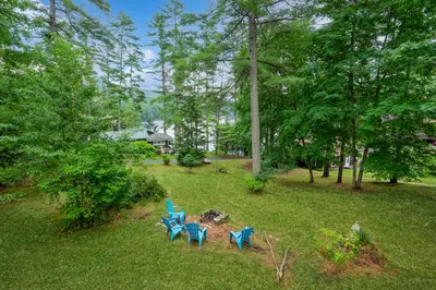a group of four blue chairs in a park at Adirondacks in Style! Lake House with Deck, Fire Pit in Hadley