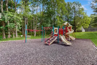 a childrens playground with a slide and a play equipment at Lounging in Long Pond in Long Pond