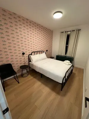 a bedroom with a large bed and a chair at The View - Direct Bus Time Square NYC Breakfast Included - D in Jersey City