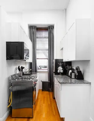a kitchen with white cabinets and a stove top oven at Studio in New York in Brooklyn