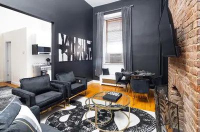 a living room with black furniture and a brick wall at Studio in New York in Brooklyn