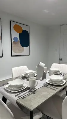 a dining room table with white plates and utensils at Open Serene Suite - 10mins-EWR, 25mins-NYC in Irvington