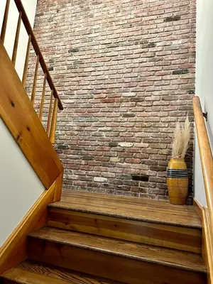 a brick wall with a vase sitting on a wooden staircase at Nature's Nest - Woodland Retreat - Fireplace - Quiet and Cozy in Bethlehem