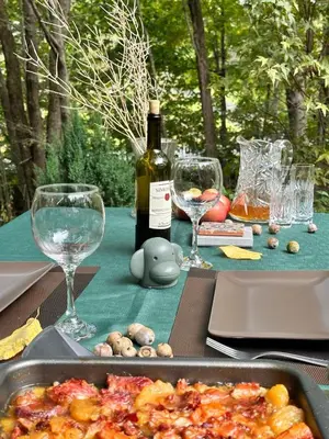 a table with a bottle of wine and wine glasses at Nature's Nest - Woodland Retreat - Fireplace - Quiet and Cozy in Bethlehem