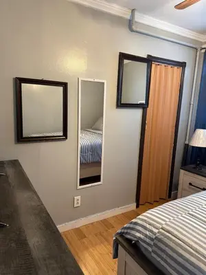 a bedroom with a bed and two mirrors on the wall at Classic king and queen suite in Schenectady