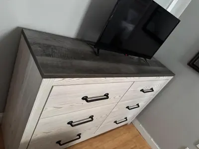 a wooden dresser with a television on top of it at Classic king and queen suite in Schenectady