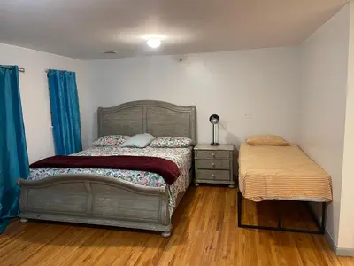 a bedroom with a bed and a dresser and a bedskirts at Peculiar 153 in Newark