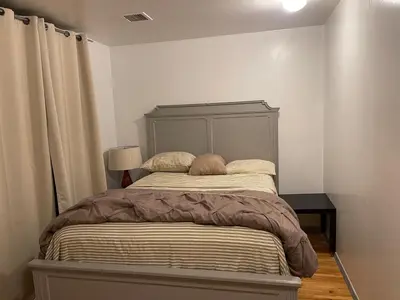 a bedroom with a bed with a gray headboard at Peculiar 153 in Newark