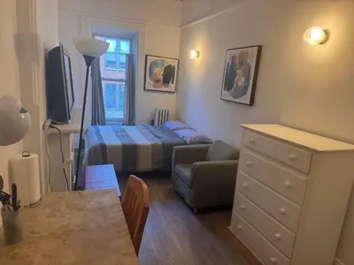 a small bedroom with a bed and a dresser at Kitchenette in New York
