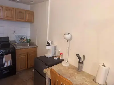 a small kitchen with a table and a refrigerator at Kitchenette in New York