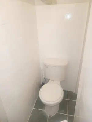 a bathroom with a white toilet in a room at Kitchenette in New York