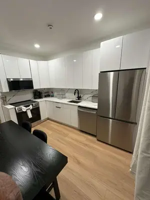 a kitchen with white cabinets and a stainless steel refrigerator at The View - Direct Bus Time Square NYC Breakfast Included - C in Jersey City
