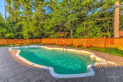 a swimming pool in a backyard with an orange fence at Charming Forest Cabin with a Hammock near Delaware Water Gap National Recreation Area, Pennsylvania in Canadensis