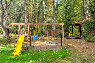 a playground with a slide and a swing at Traditional Wooden Cabin Rental in the Poconos, Pennsylvania in Canadensis