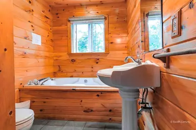 a bathroom with a tub and a sink and a toilet at Idyllic Log Cabin Rental with a Porch in the Poconos of Pennsylvania in Canadensis