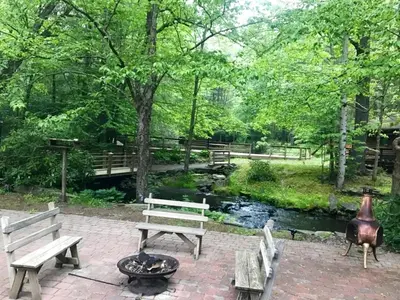 a park with benches and a fire pit next to a creek at Private Cabin Rental with Wood-Burning Fireplace in Canadensis, Pennsylvania in Canadensis