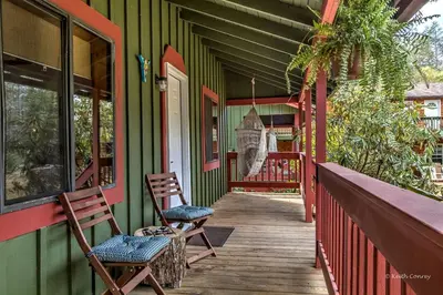 a porch of a house with two chairs on it at Private Cabin Rental with Wood-Burning Fireplace in Canadensis, Pennsylvania in Canadensis
