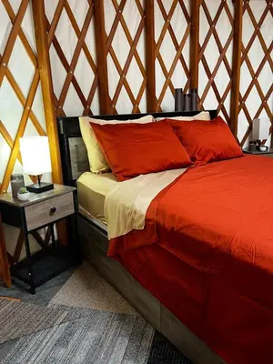 a bedroom with a bed and a table with a lamp at Incredible Equipped Yurt Amazing for a Glamping Experience in East Meredith, New York in East Meredith