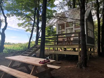 a large tree house with a picnic table in front of it at Romantic New York Getaway near the Adirondacks in Cambridge