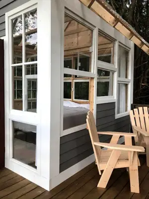a screened in porch with a bed and a chair on a deck at Romantic New York Getaway near the Adirondacks in Cambridge