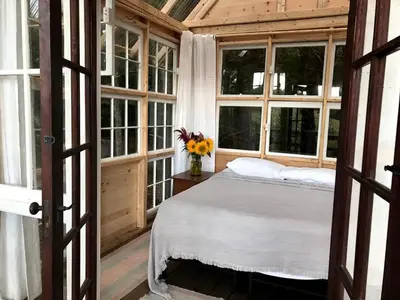 a bedroom with a bed in a room with windows at Romantic New York Getaway near the Adirondacks in Cambridge